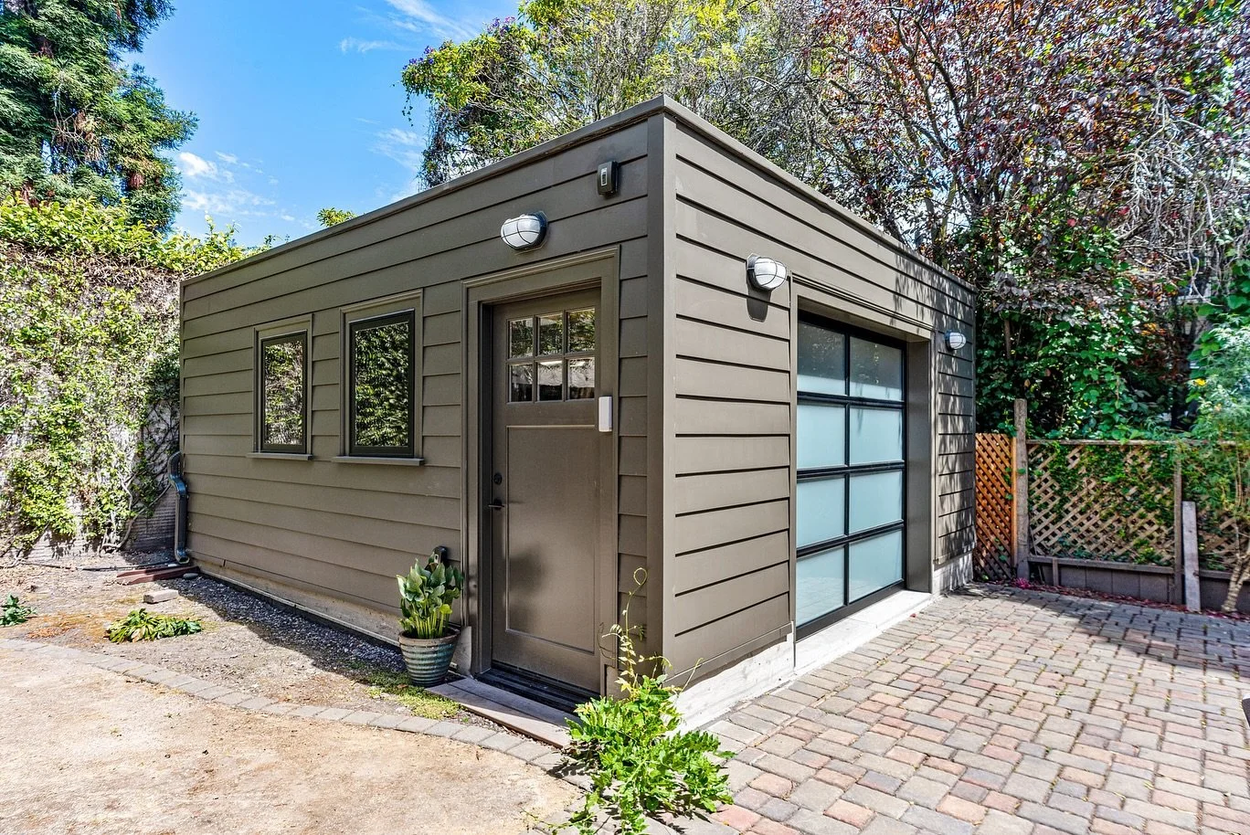 We lifted this garage (literally and figuratively)! What was once a flooded, cluttered space is now a sleek, modern garage built for both function and style. With its black exterior, frosted glass door, and warm wood ceiling paneling, it&rsquo;s a st