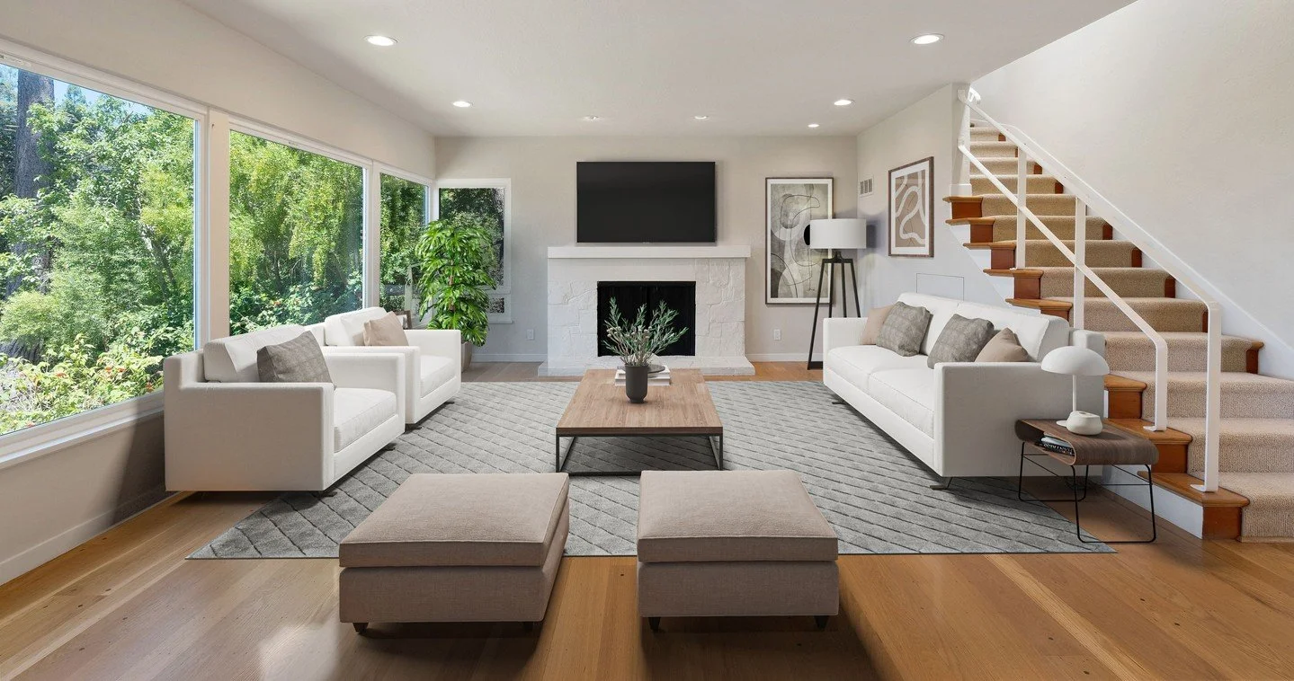 Designed to frame the view. This living room remodel opens the home to gorgeous Bay views through expansive windows, flooding the space with natural light. A new fireplace anchors the room, while upgraded flooring and a reimagined staircase add warmt