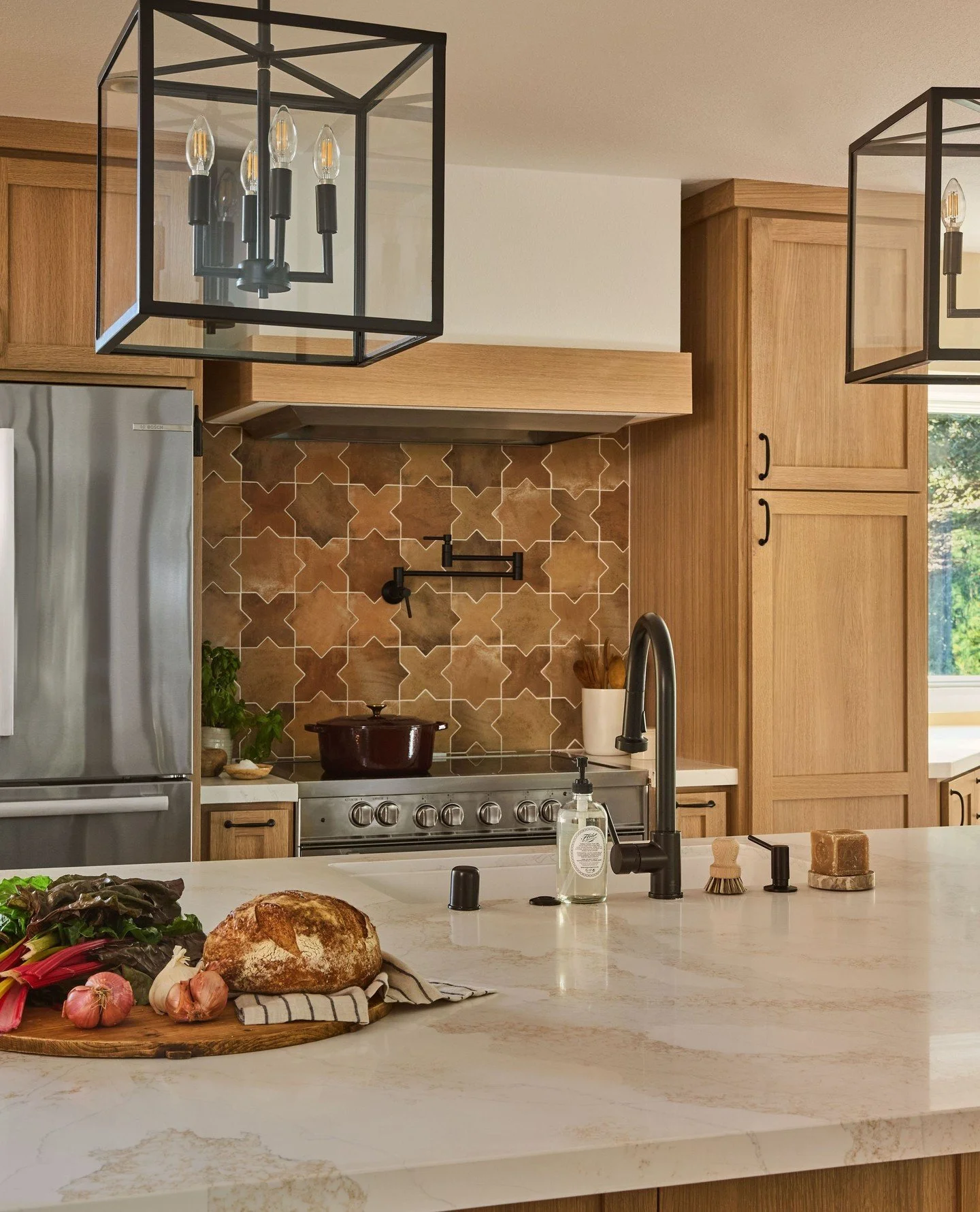 Warm wood tones, statement lighting, and a patterned backsplash that steals the show ✨ This kitchen remodel blends modern lines with cozy textures for a space that&rsquo;s as inviting as it is functional.