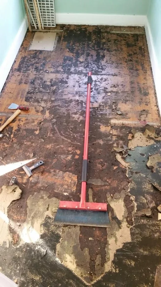 Hardwood peaking up out of the remnants of the old nasty floor!