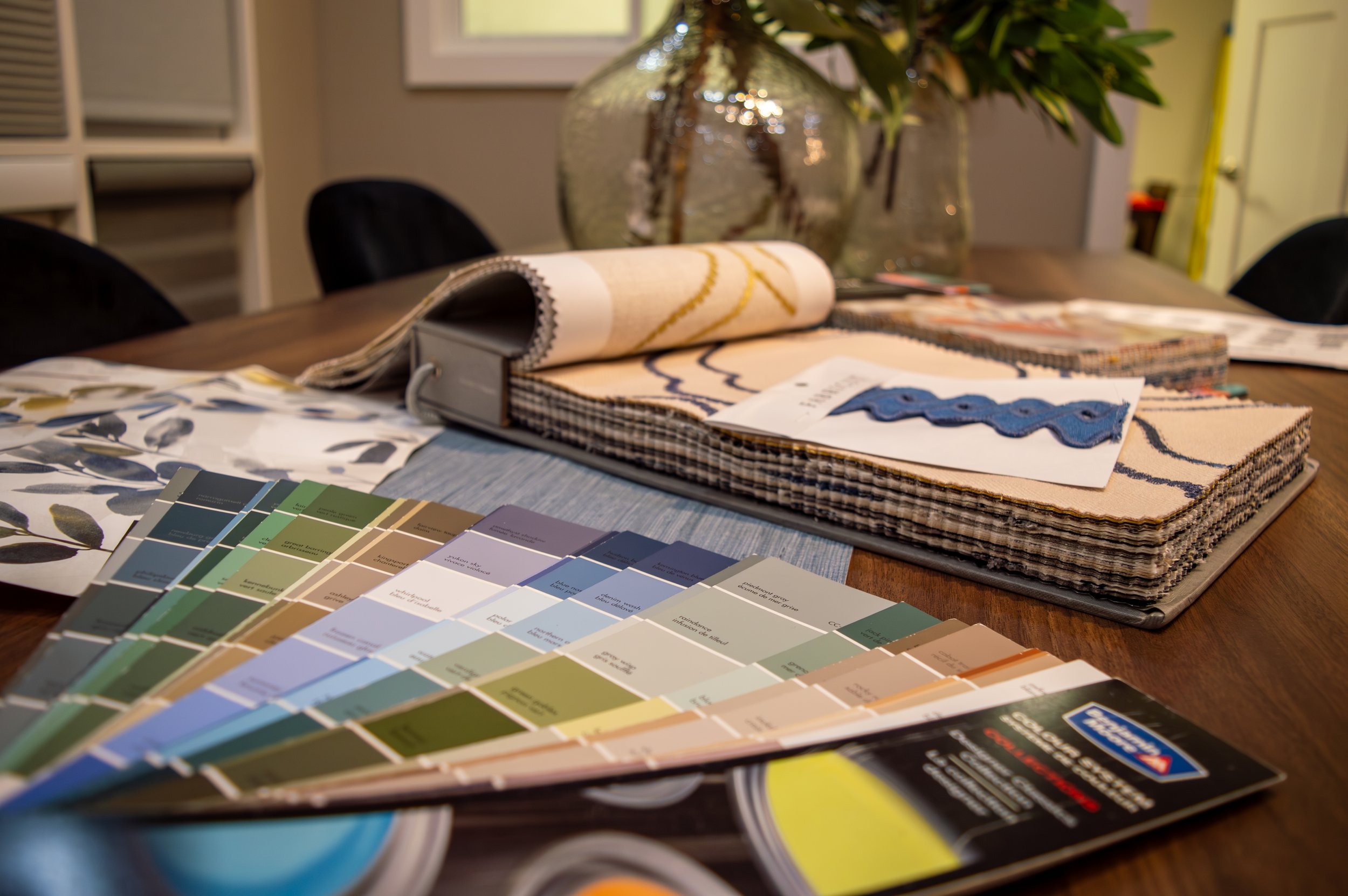 Paint chips and fabric samples spread over a table.