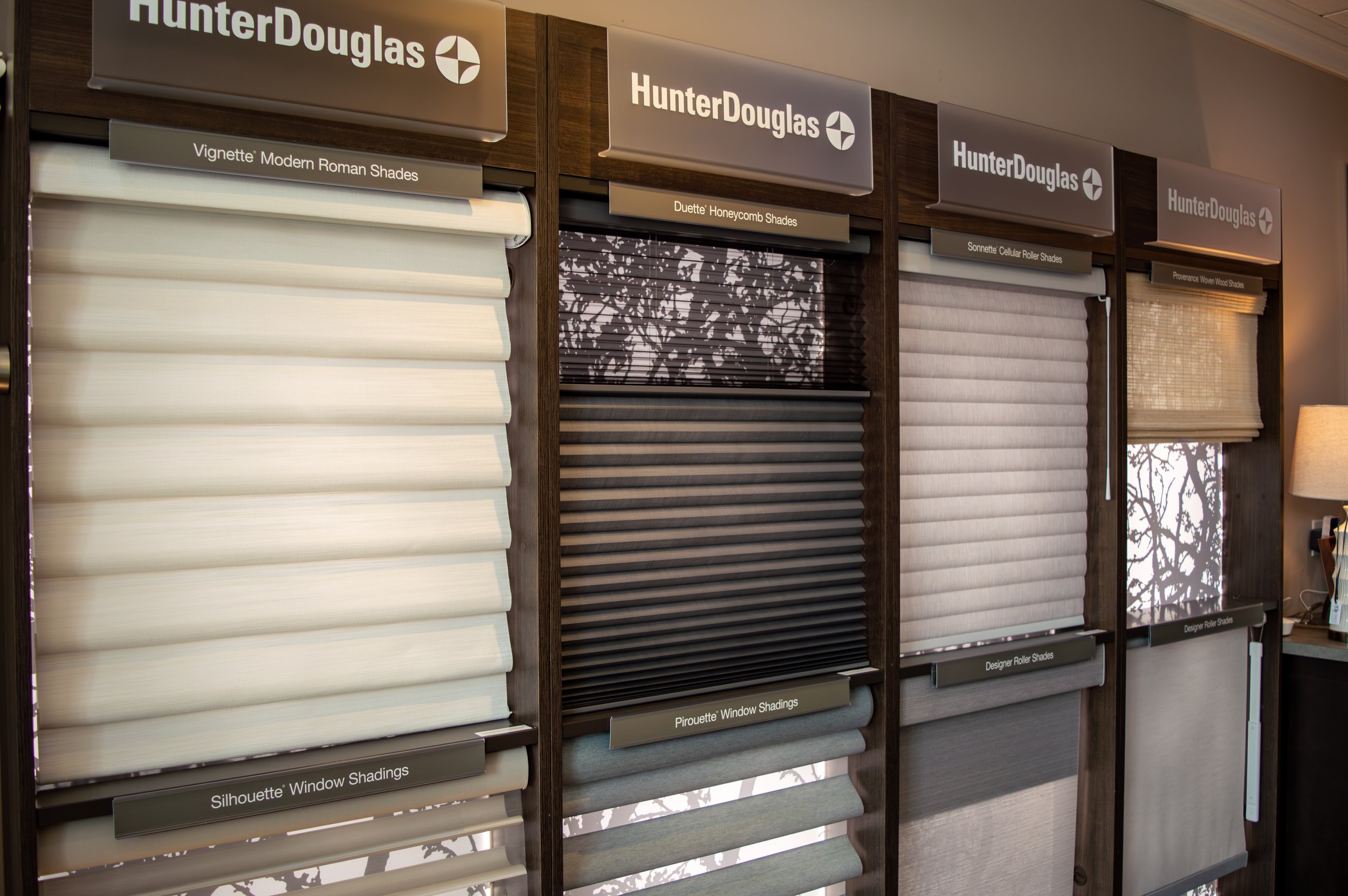 Variety of Hunter Douglas blind options displayed on a wall.