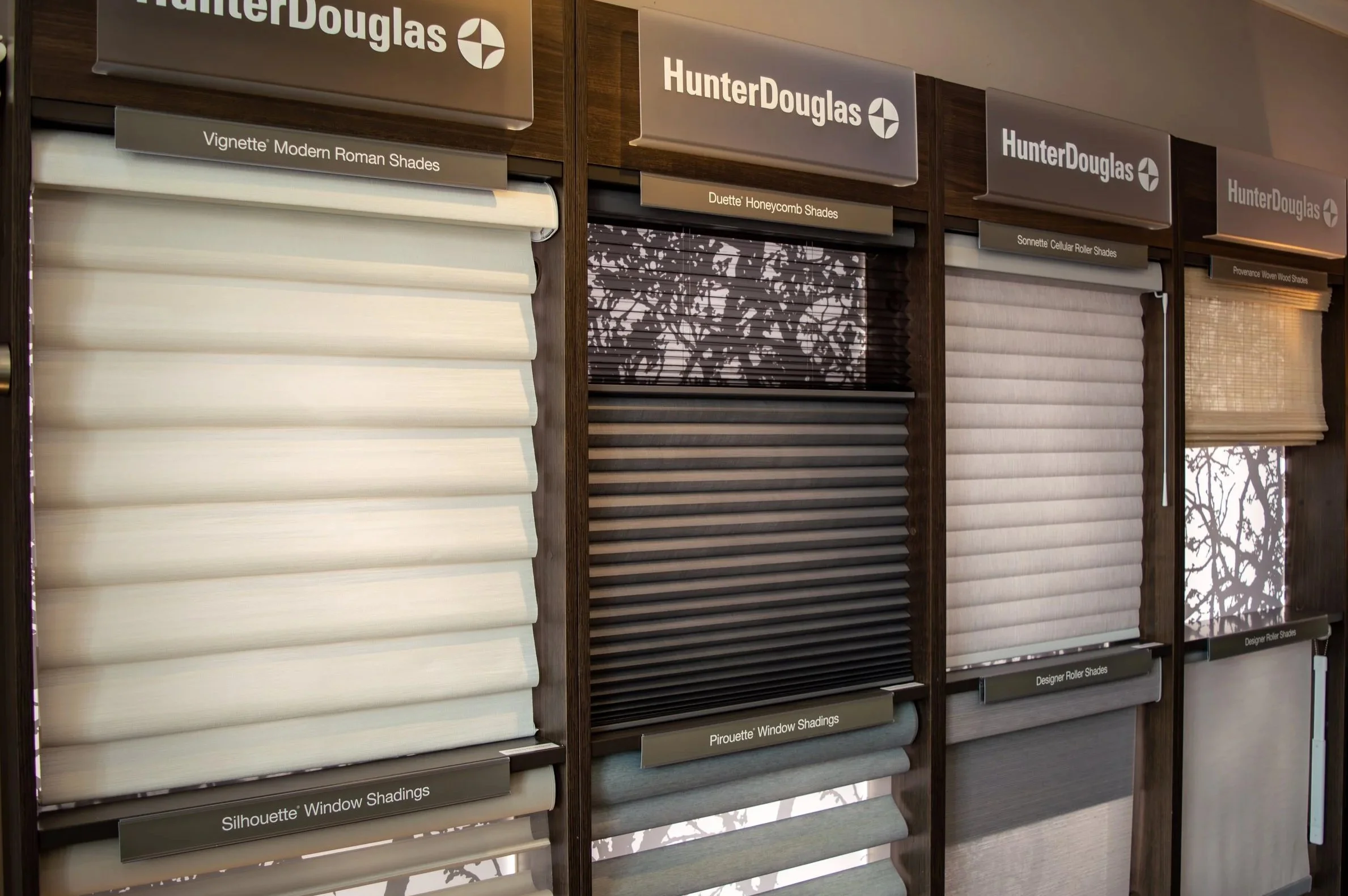 A wall display featuring various styles of Hunter Douglas blinds.