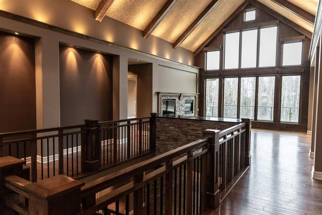 Inside of a new unfurnished home, with vaulted ceilings, and a full wall of windows.