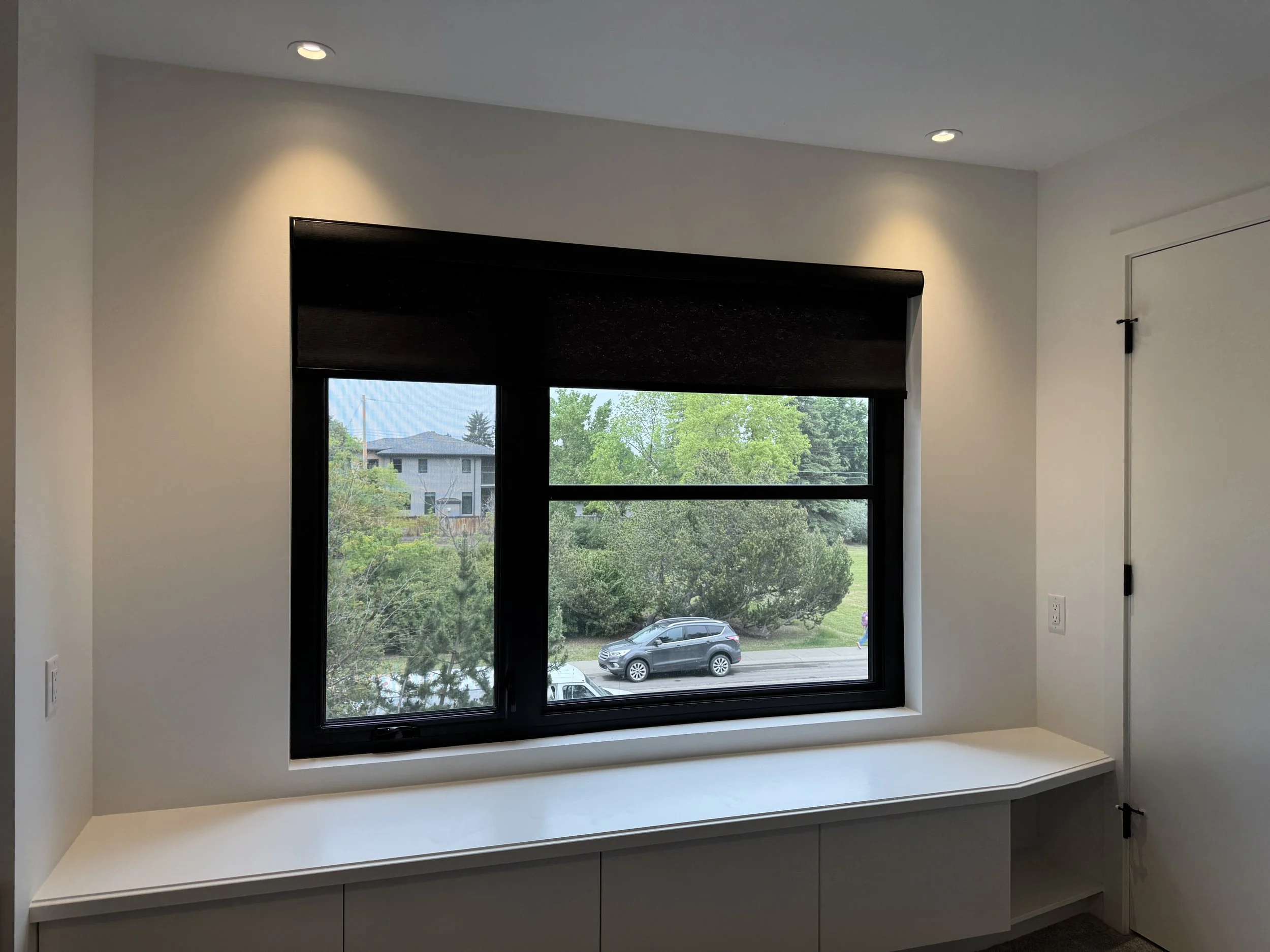 Black blinds fitted over a black window frame.