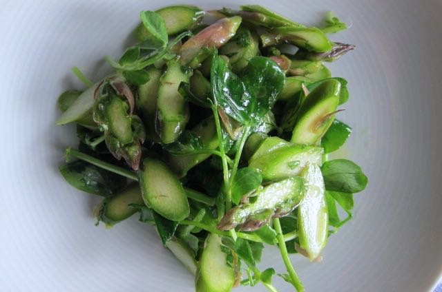 Raw Asparagus Salad Photo ©Evie Saffron Strands We collected the first cut of English Asparagus from our Kent Grower last week and, despite a return to lacklustre weather, the English season is definitely under way. Here is a recipe, inspired by our friends at 40 Maltby Street, celebrating the early spears which are delicious eaten raw. It also makes a few spears go a long way. Raw Asparagus Salad (Serves 4 as a starter) 8-12 asparagus spears A handful of pea-shoots A few mint leaves 1 tbsp lemon juice 4 tbsp extra virgin olive oil Salt & pepper Snap the tough ends off the asparagus. Cut a diagonal slice off the bottom of each spear then slice them thinly. Add salt and pepper to the lemon juice and mix. Whisk in the olive oil to emulsify. Toss the sliced asparagus and the pea shoots in the dressing. Pile onto plates and serve. (Add a few curls or a grating of Italian Parmesan or English Berkswell cheese if you like). 