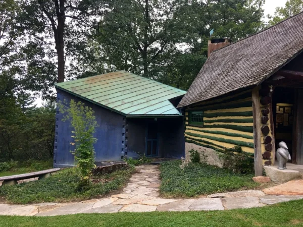 Log garage to the right is currently used as the welcome center. Blue building to the left was the last building added in 1956.