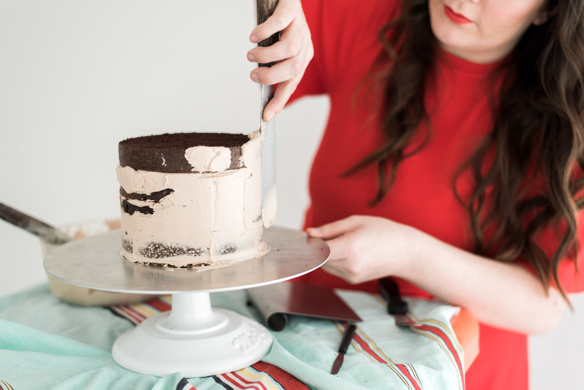 Bellingham cake maker, Saltadena, smooths her creation in preperation for chocolate drips.