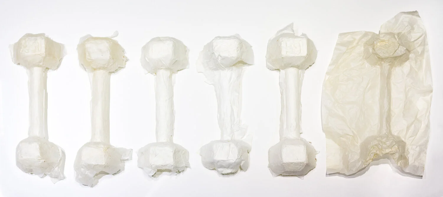 A series of paper sculptures that are shaped like the same small dumbbell