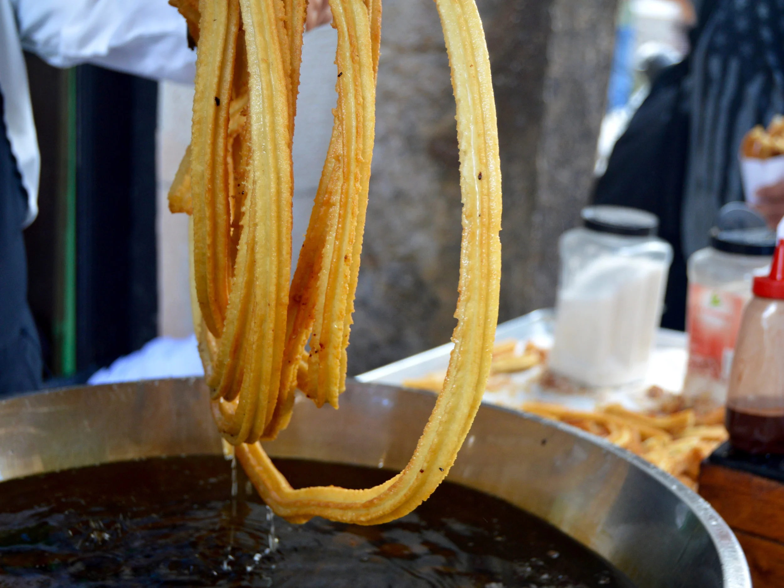 A Cuban man dresses churros with chocolate sauce for tourists in central Havana. Photo by Caroline Leland 
