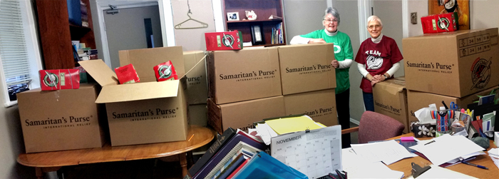  Some of the 600 shoe boxes collected in the highlands, with brenda watson and chief coordinator, kathy burk