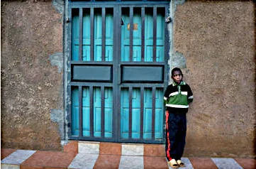 Clinton stands at the gates of the church where he received an Operation Christmas Child shoebox