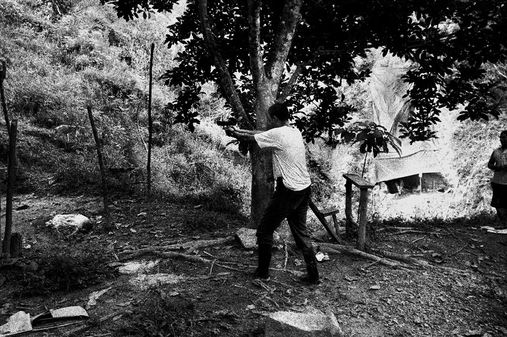   Bodyguard of Dairo Rúa practices firing his pistol in secluded area of Segovia, Antioquia. Like other leaders of the miners union, Mr. Dairo Rúa at the time president of the Segovia section of the Sintraminergética miners union, has been subject to