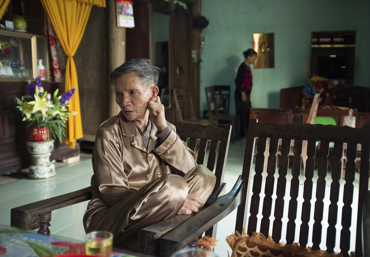 Hoang Van Sy reciting a poem to welcome visiting guests to his home after his heart surgery. © Tran Quoc Ahn