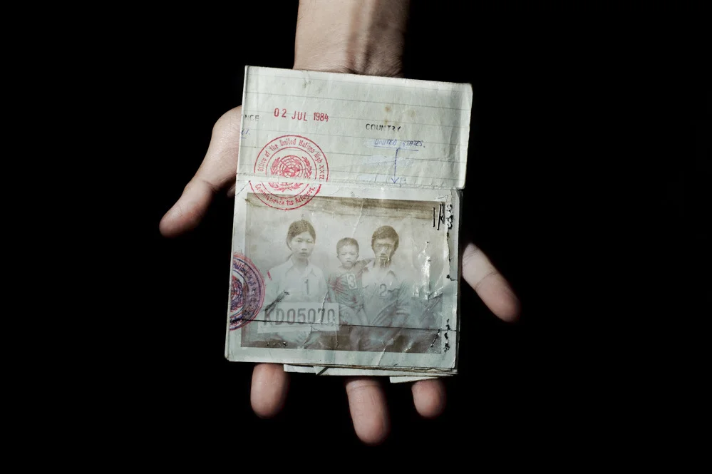 Sunny Vaahn, 25, a graduate of Carnegie Mellon, holds the refugee identification card of his family members. The photograph was taken upon their initial entry into a refugee camp after their arduous trek across the Thai border following the end of Khmer Rouge rule in Cambodia. The family made the trek because they were told that there was food on the other side of the border. © Pete Pin, 2011 MF Fellow.