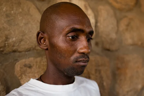 Sani Umaru, 44, stared vacantly into space most of the time. His voice had been reduced to an almost inaudible mumble. He arrived at the Yola Federal Medical Centre in late October. Both of his hands were wrapped in thick bandages due to gunshot wounds so severe that they say his left hand will have to be amputated. He remembers Boko Haram men making him lie down in a road-side gutter with five other men, just before the execution style shooting. He was a farmer from Madagali town before the attack and the only survivor of the shooting. 2014, © Rahima Gambo