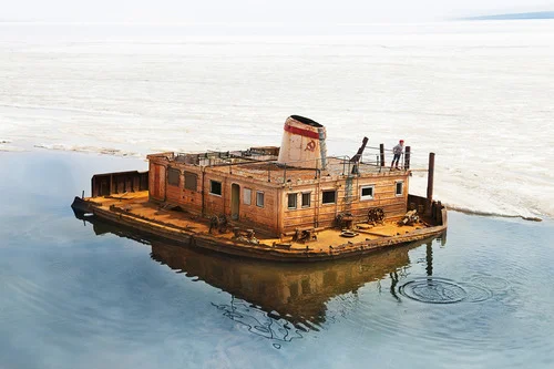 “Letting frogs out” (stone skipping) from rusty barge.
