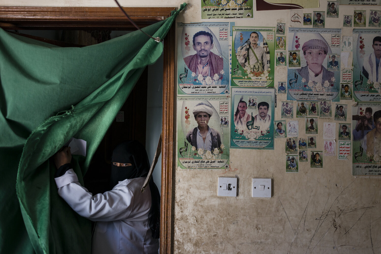  A nurse retrieves supplies at the malnutrition center supported by WHO on May 7, 2018 in Bani Mansur, Yemen. Photos of Houthi martyrs hang on the walls. 