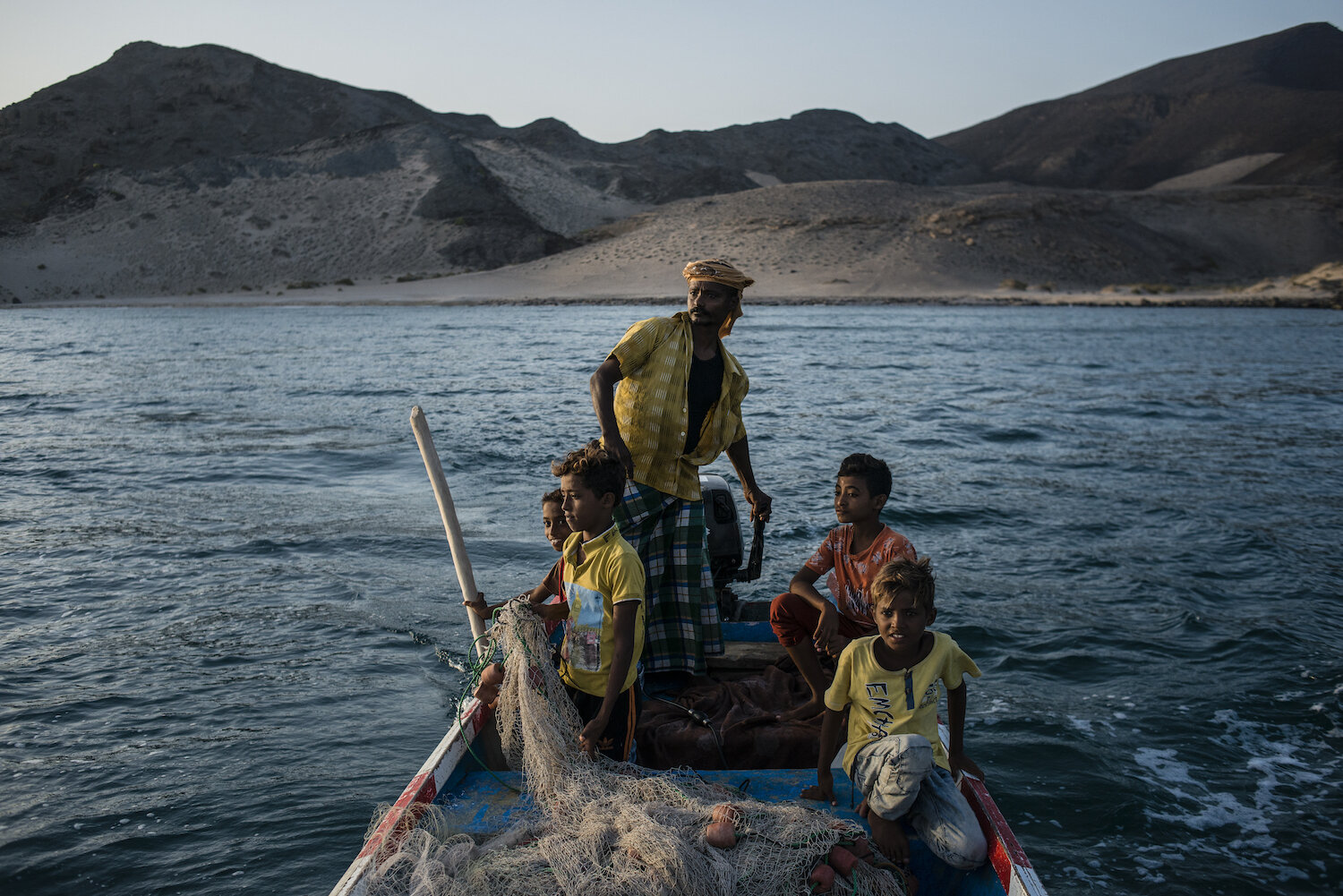  Shafai (center) drives a boat near the shore in search of schools of fish to catch on May 9, 2018 in Fugum, Yemen. 