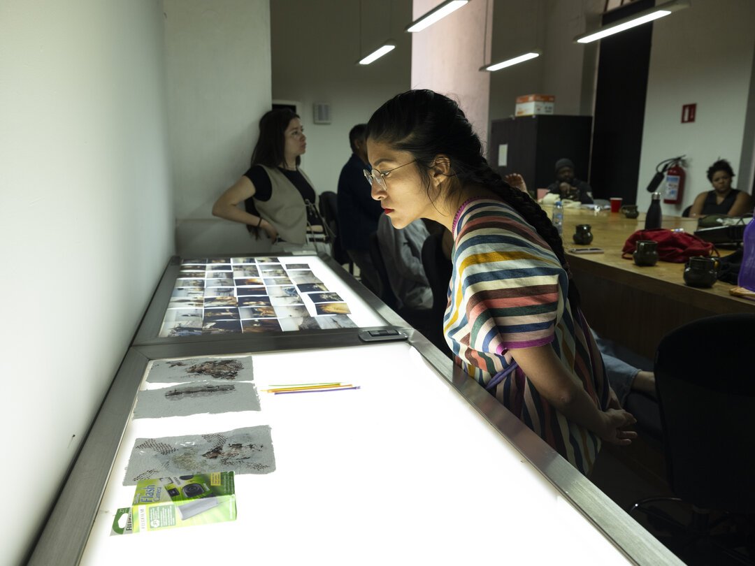  MF alum Citlali Fabián looks at in-progress work by the Heat Fellows. 