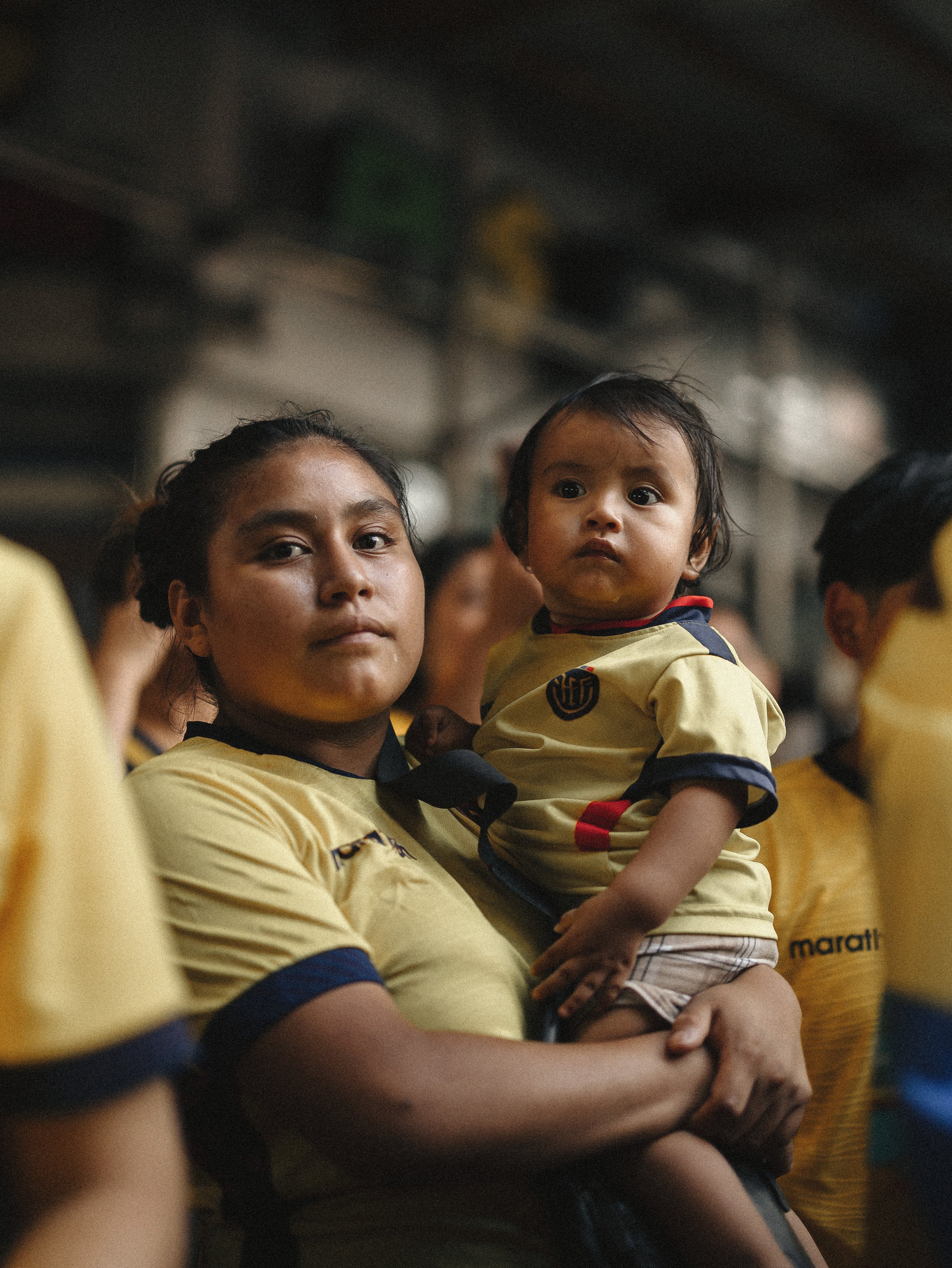  An Ecuadorian mother holds her child among supporters gathered at Boulevard Junction in Jackson Heights, Queens, during the Mexico vs. Ecuador match, June 30, 2026. 