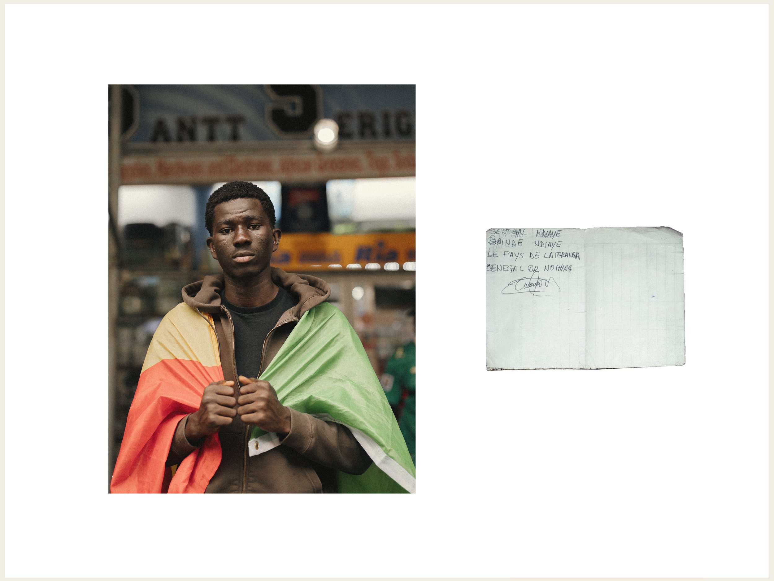  A Senegalese supporter stands beside a handwritten note referencing “Lions de la Teranga,” the nickname of the Senegal national team, during the Senegal vs. Iraq match gathering in Harlem, New York City, June 26, 2026. 