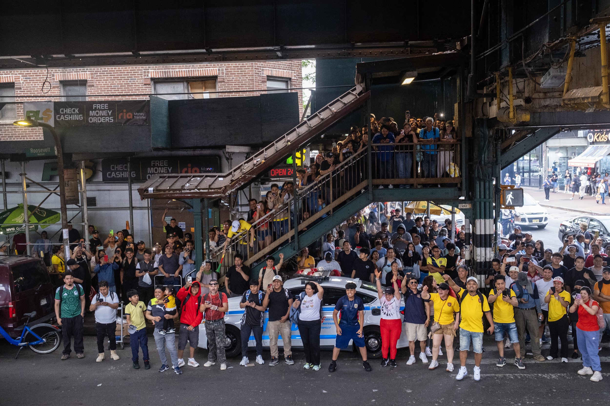  Fútbol fans take over the streets to watch a 2026 FIFA World Cup match at an outdoor watch party, where the game is broadcast on screens mounted to a converted ambulance beneath the elevated Junction Boulevard 7 train on Roosevelt Avenue in Jackson 