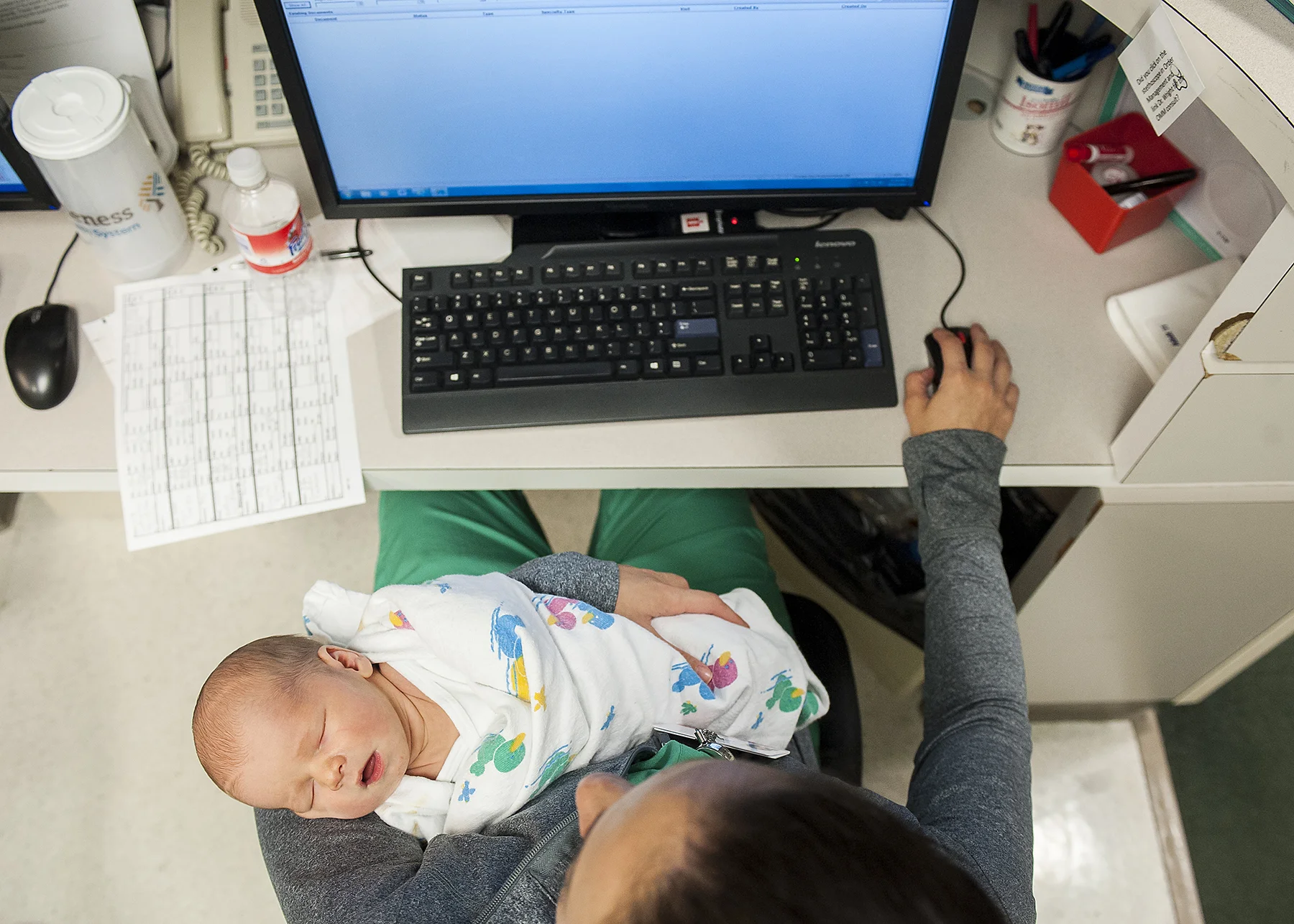  Dr. Berry cares for a restless two day-old infant while also checking on patients charts while on call. Dr. Berry says, "I chose to do this because it makes me happy. And I haven't found anything else that makes me happier." 
