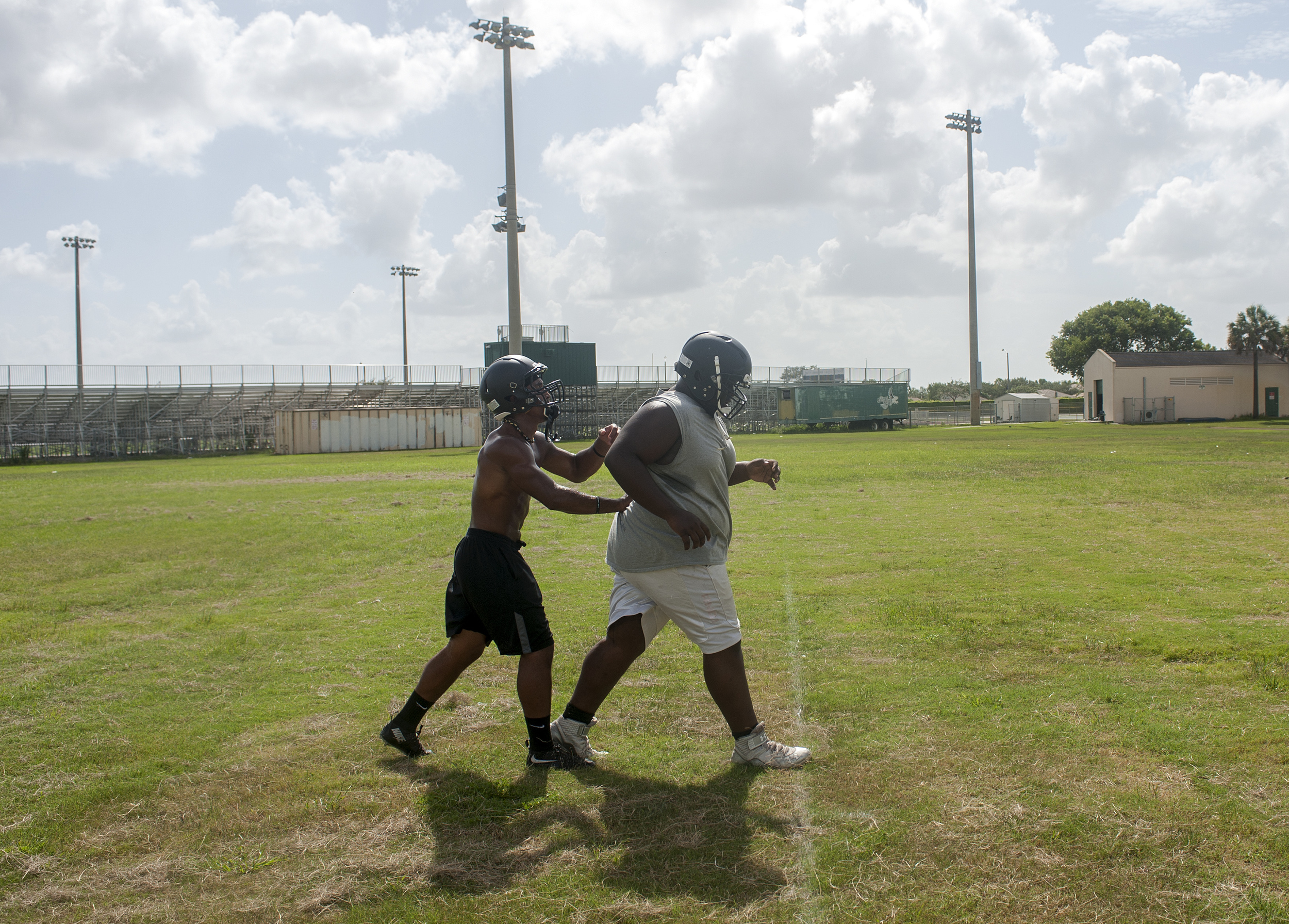  Flanagan high school senior wide receiver Clevan Thomas helps one of his teammates during conditioning drills on the first practice of the high school football season at Flanagan High School on Monday, Aug. 1, 2016. The reigning state champions look