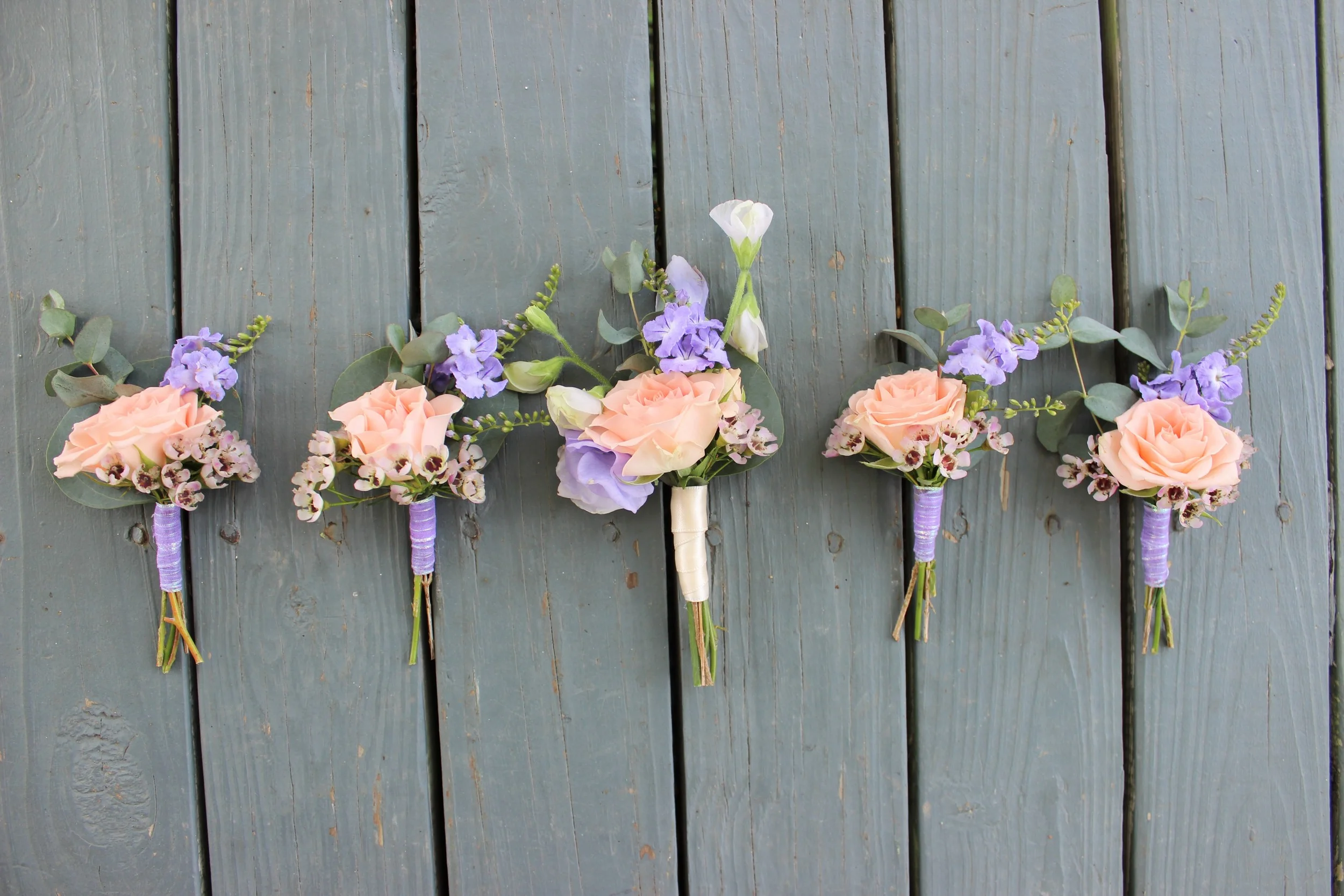 Matching boutonnieres of spray roses, sweet peas and wax flower. The groom stands out in ivory! Photo by The Floral Cottage