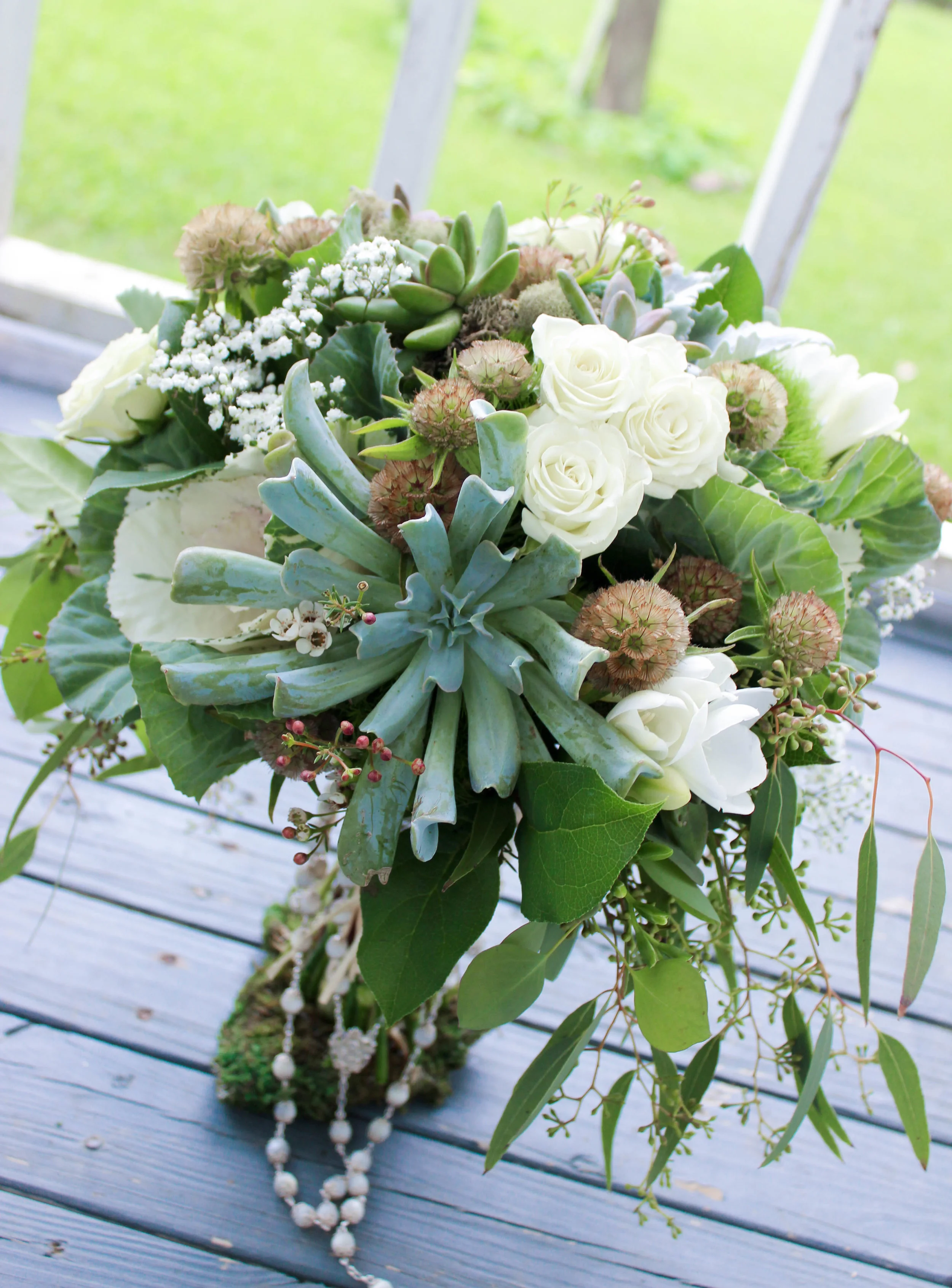 The bride's bouquet featured succulents, scabiosa pods, kale, eucalyptus, dusty miller and few ivory spray roses, freesia and baby's breath sprinkled in to add a touch of softness.