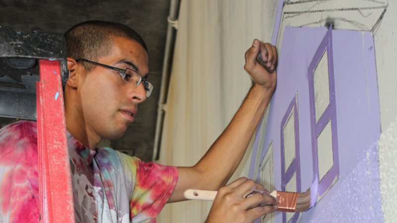 Antonio Ramos painting at the West Street Mural.