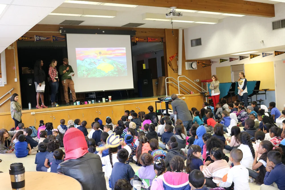 AHC Executive Director Amana Harris, Lead Muralist Lindsey Milliken, and Project Manager Justin Metoyer Mullon reviewing preliminary drafts of the #4th OSH Mural design with the Hoover Elementary Student Body.
