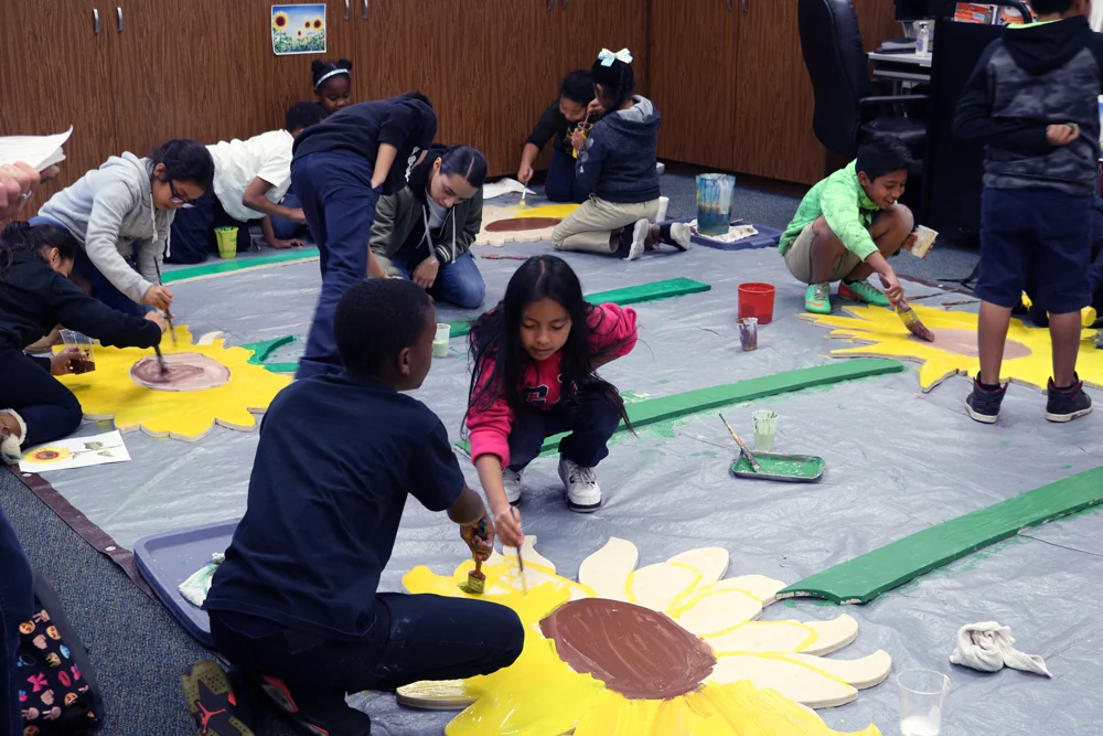 Hoover Youth Leadership group painting larger-than-life sunflowers to be installed in the school community garden.