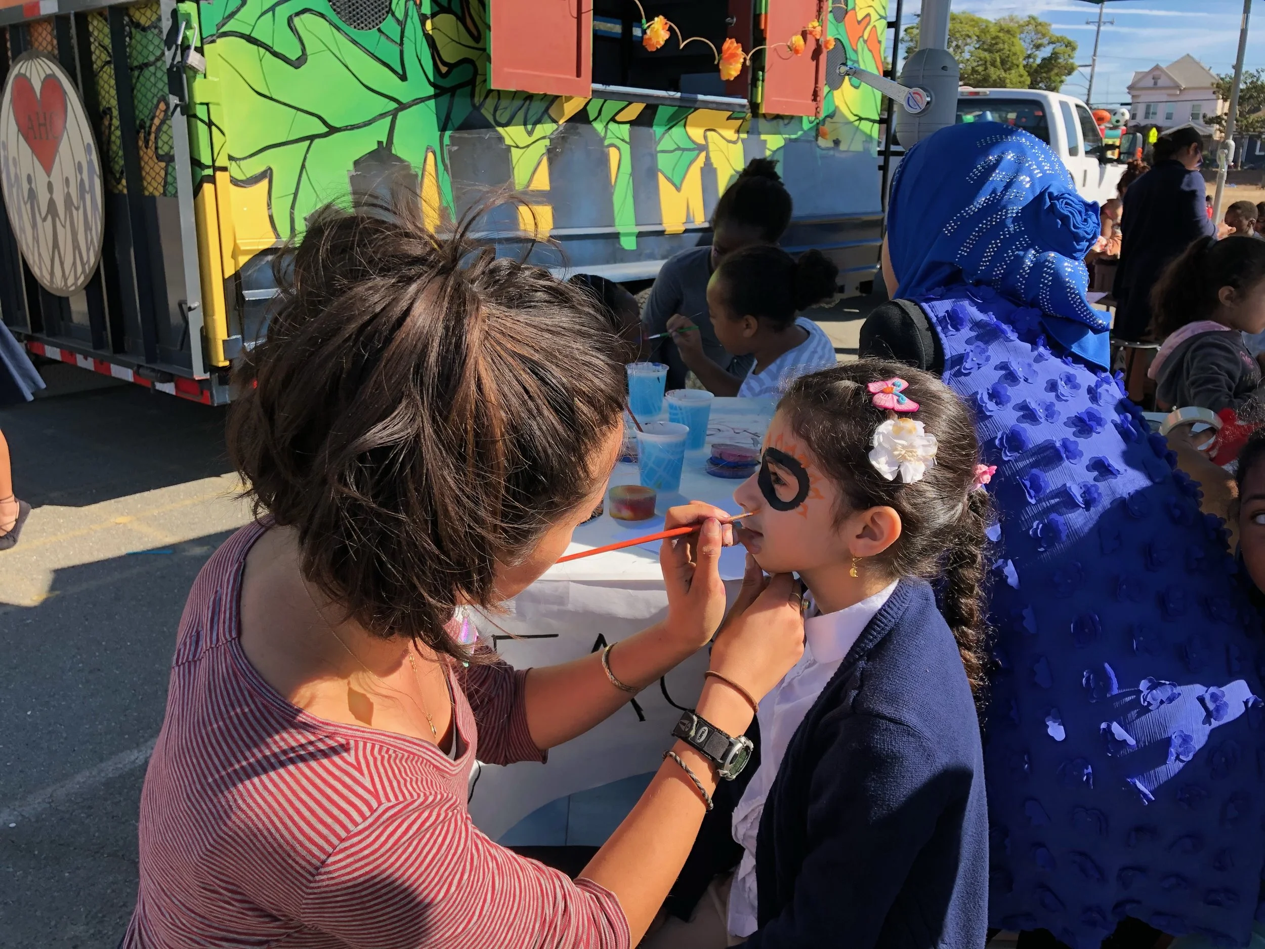 To the left our Hoover staff, Neeka, face painting a student with a sugar skull design.