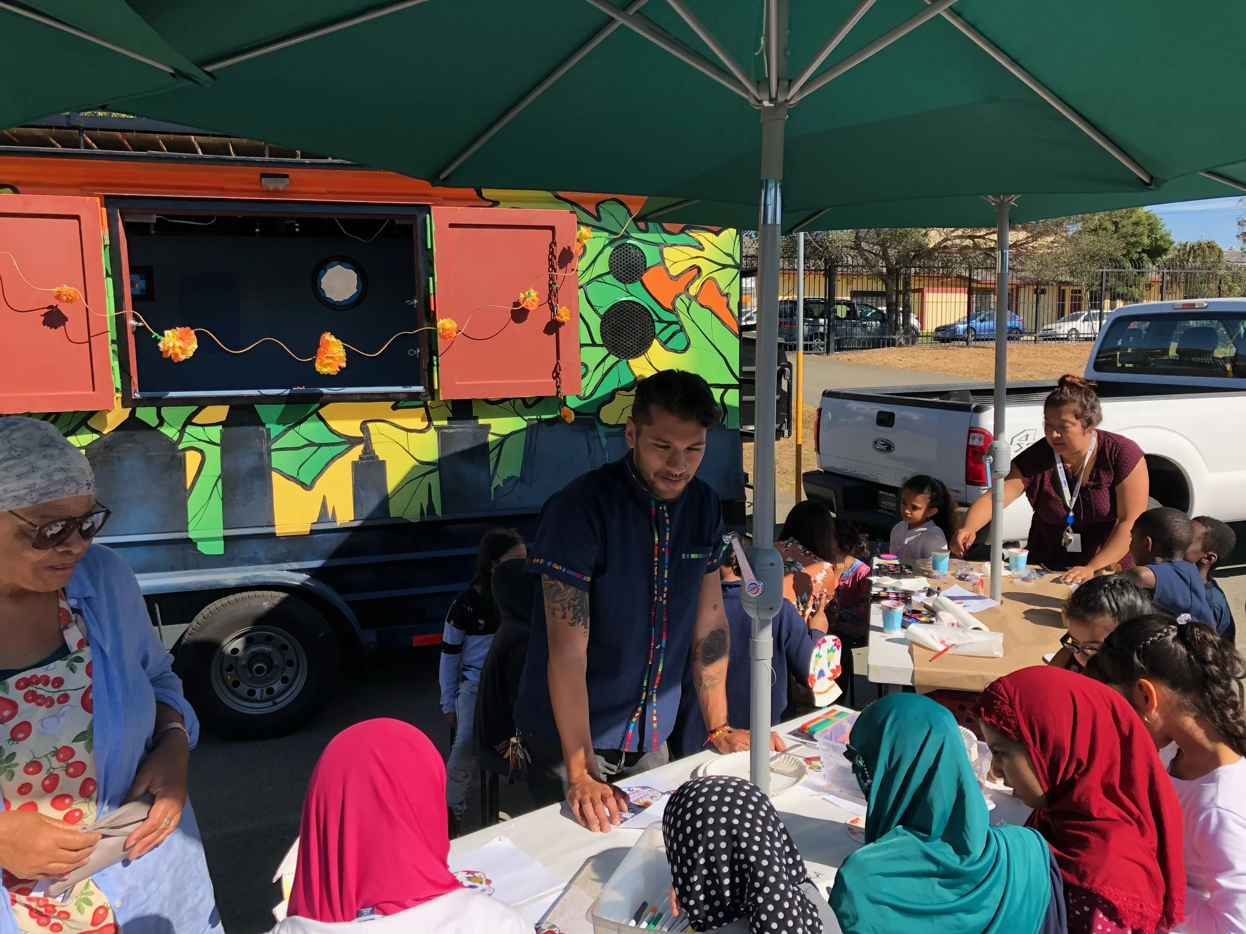 In center our staff, Eduardo, facilitating a calavera mask making lesson.