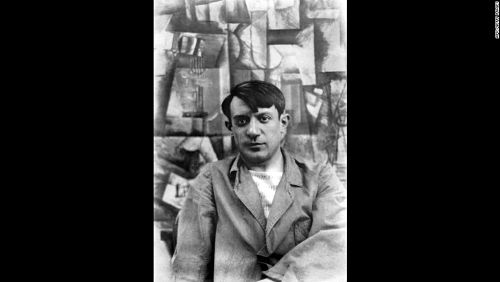 Picasso around 1911 in front of a cubist work.