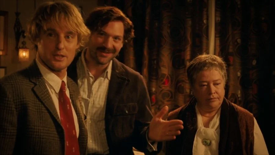 Still from Midnight in Paris with Owen Wilson as befuddled writer Gil Pender, Corey Stoll as Ernest Hemingway, and Kathy Bates as Gertrude Stein.