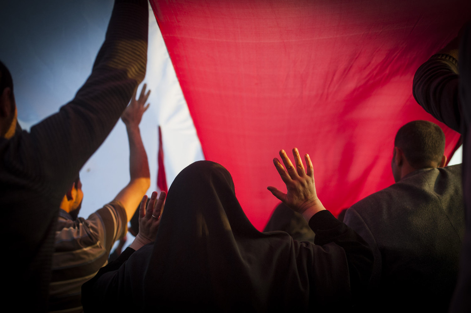  A woman walks under an Egyptian flag in Tahrir Square in Cairo Egypt. After the January 25th protest, demonstrators occupied Tahrir Square in Cairo, Egypt and demanded the overthrow of the regime of Egyptian President Hosni Mubarak. 