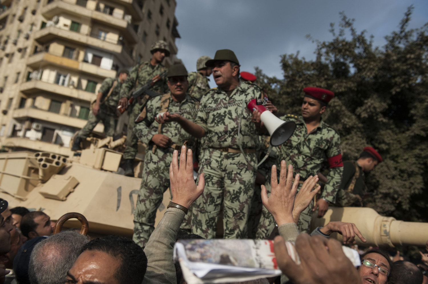  An army general attempts to reason with the protesters as they sit in front of tanks to stop the army from entering the square.  