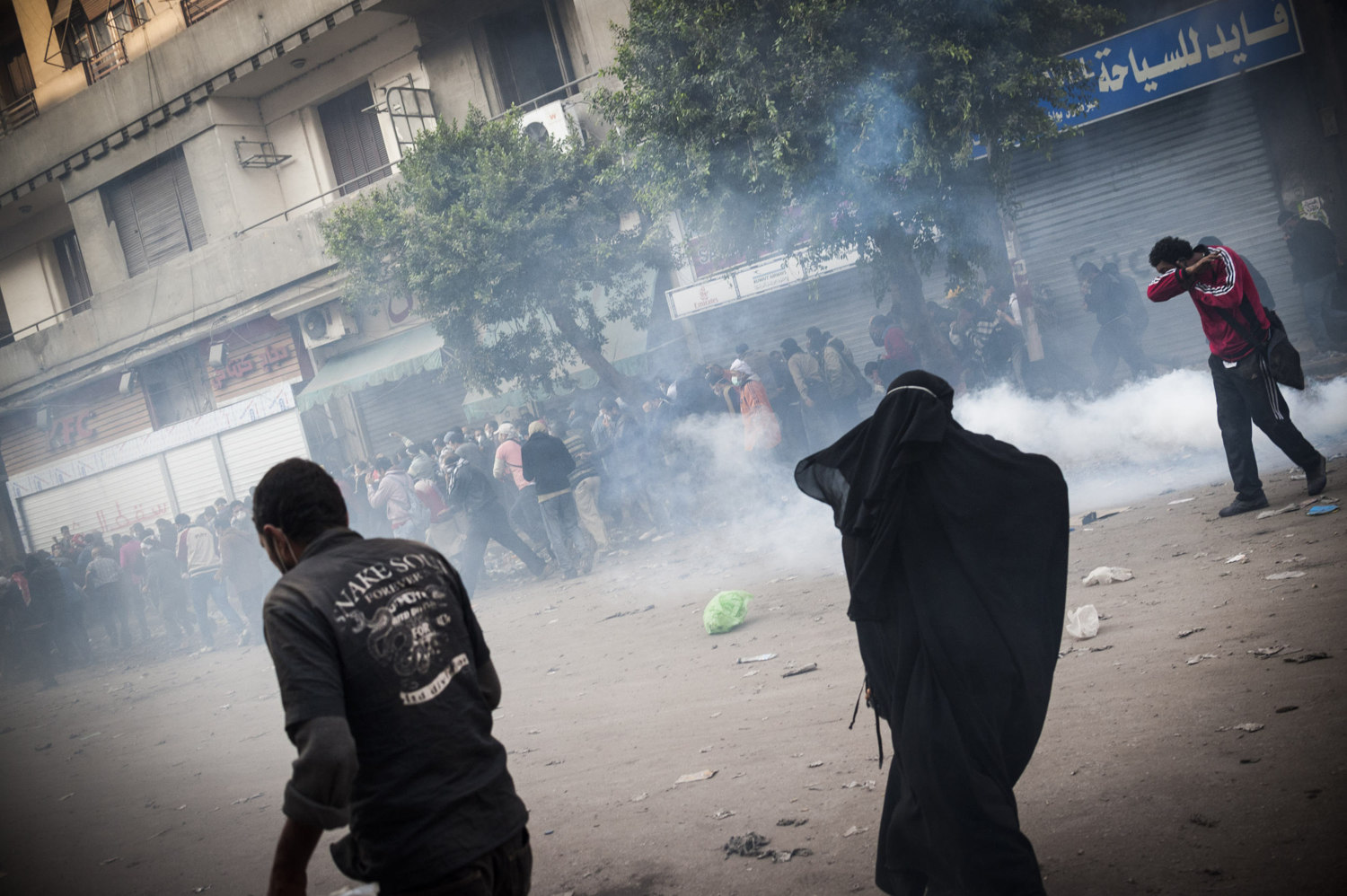  A woman runs from teargas and rubber bullets shot off by the Egyptian riot Police on November 22nd 2011.  Protestors gather in Cairo’s Tahrir square to speak out against SCAF, the Supreme Council of the Armed Forces, which has governed Egypt since t
