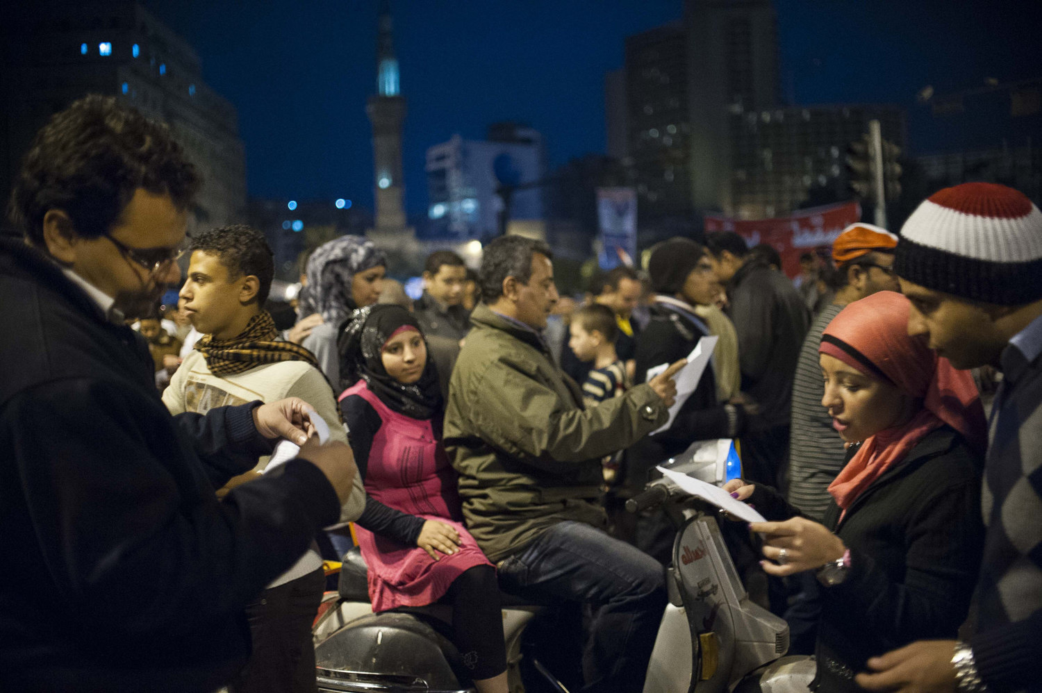  Egyptians read ballot forms with candidate information handed out in Cairo's Tahrir Square the night before elections on November 27th, 2011. 