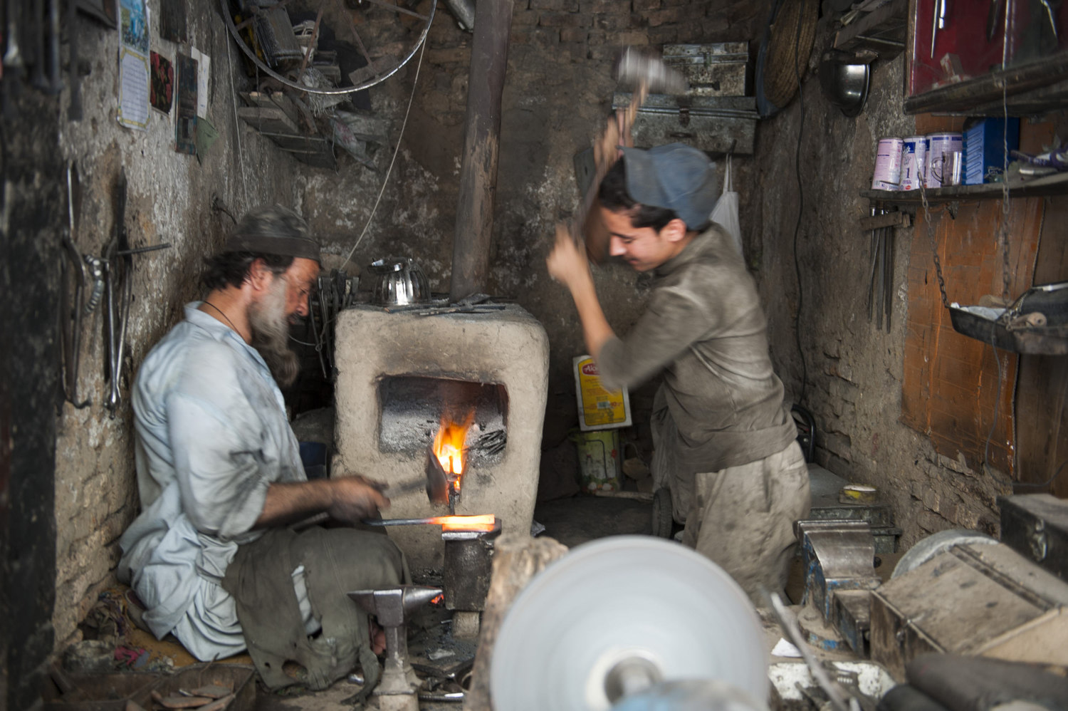  A father and son metalworking team work in downtown Kabul. The rate for skilled labor is 5 dollars a day and trades are traditionally handed down through the family. 