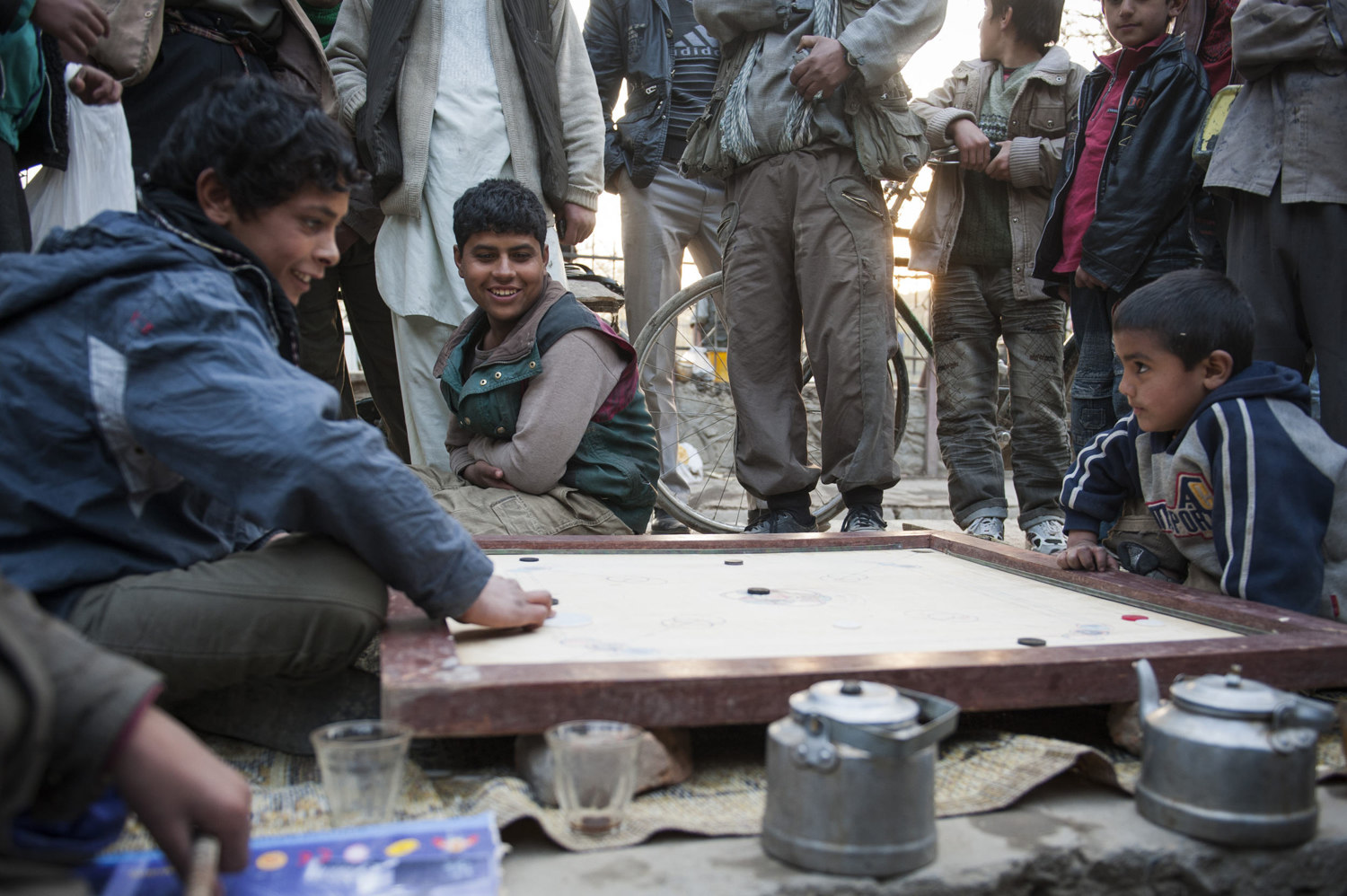  Children play Carambol in Cinema Park in Kabul. Mavid, age 12 right is playing Ravi, age 6. Though Ravi is the youngest and smallest player he has won his fifth straight game.  