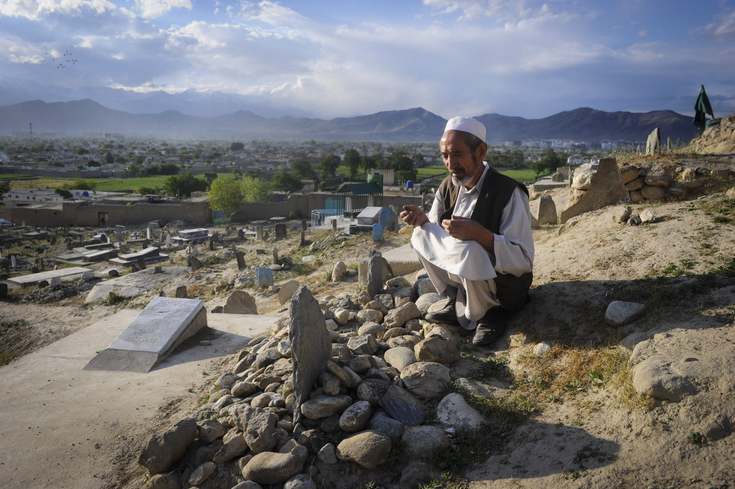  A deaf man prays at the grave for his relative. 