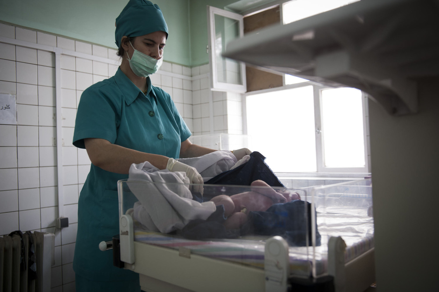  A birthing assistant wraps up a recently born baby. Midwives are being trained to deal with delivery complications, like this baby who breeched during the delivery but was delivered successfully.  