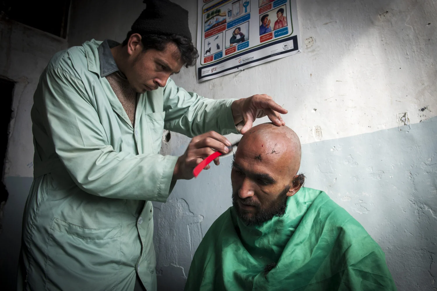  Abdullah Wahid enters the Jangaland rehabilitation clinic in Kabul, Afghanistan. The admittance procedure involves shaving the head as a sign of a new commitment. 