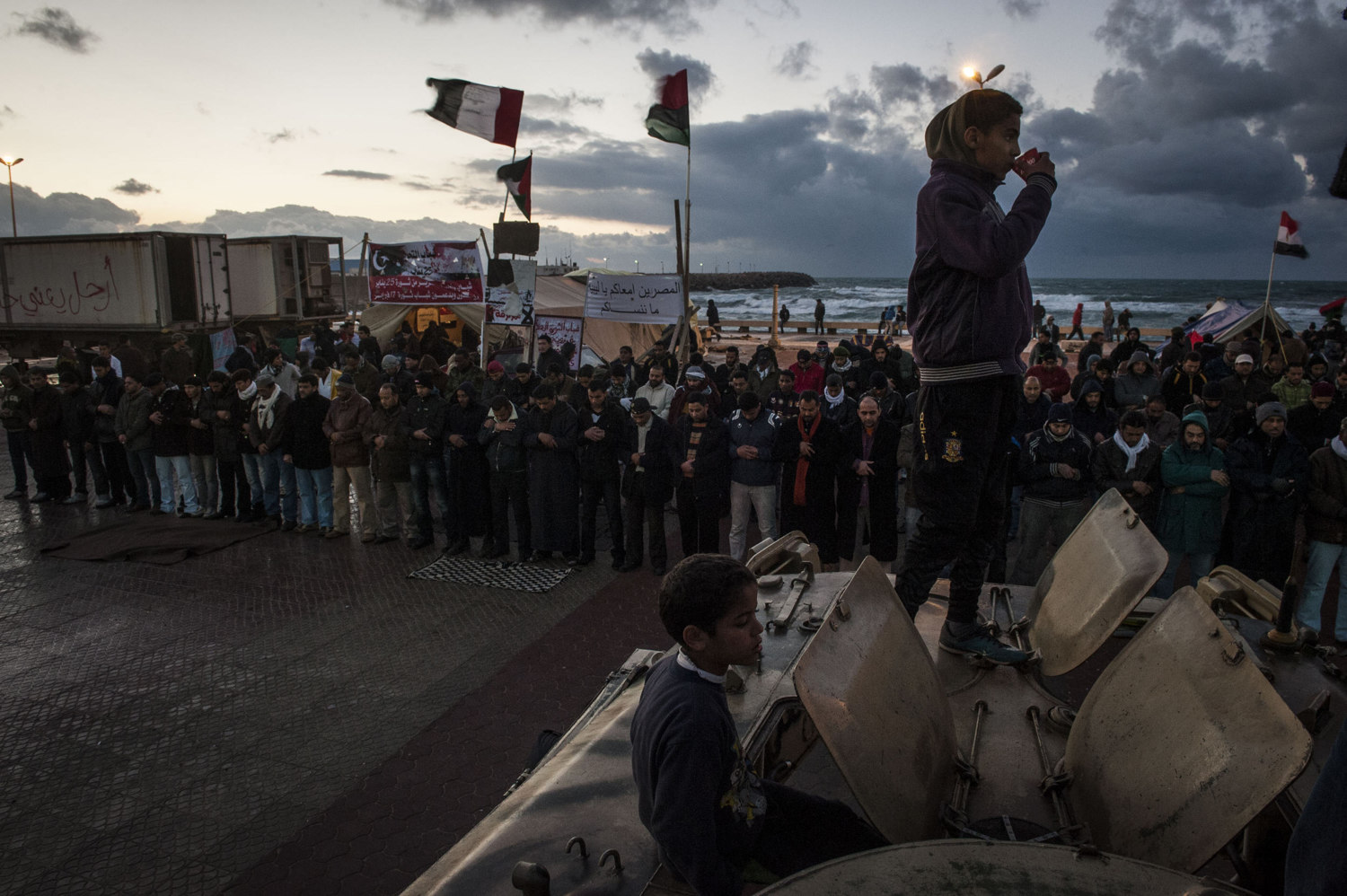  Men pray during evening prayers in front of the courthouse in downtown Benghazi where the protests and provisional governments are based on February 27th, 2011. Benghazi has been liberated by resistance forces and no longer is under the rule of Col.