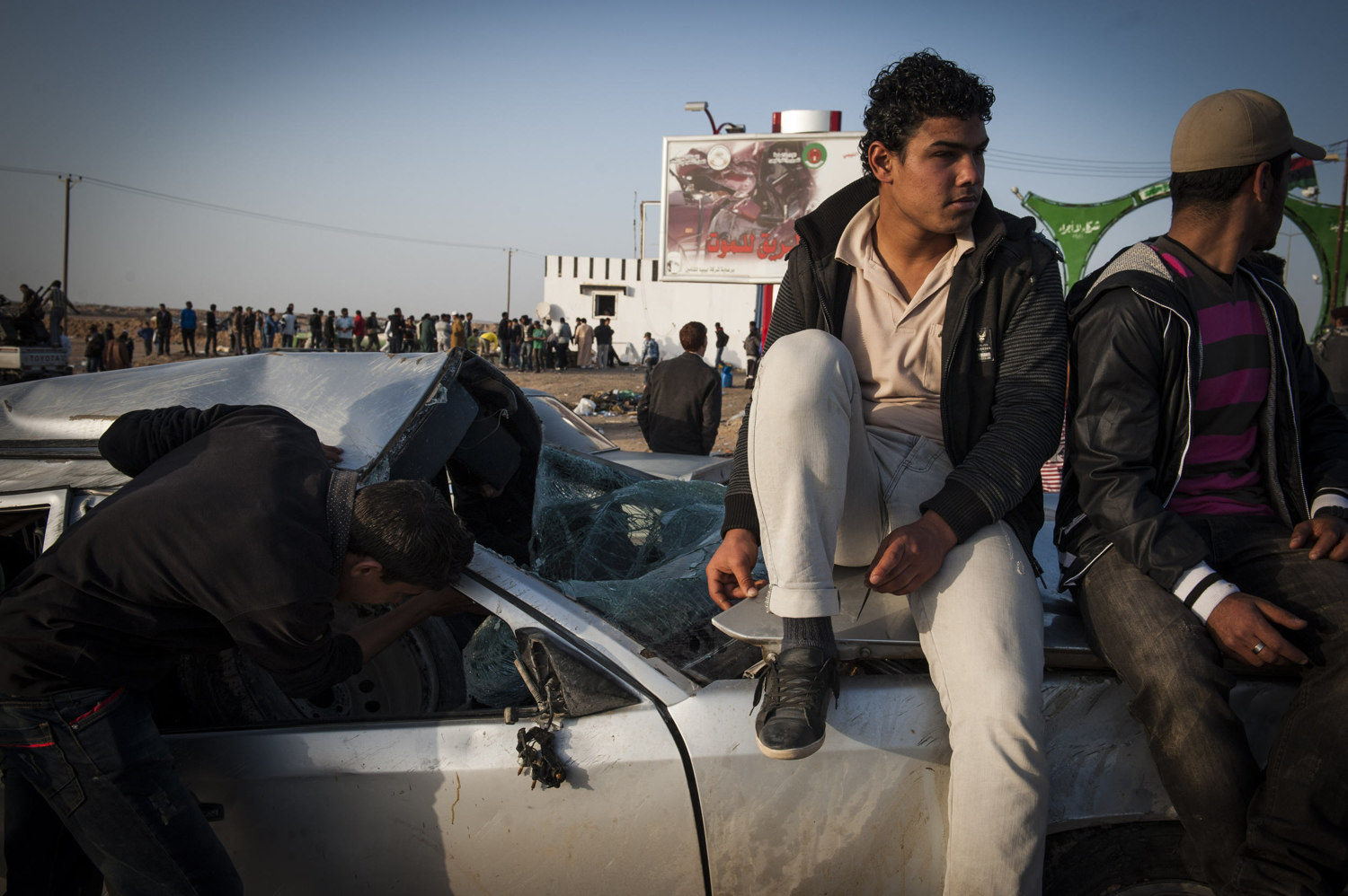  Boys sit on a broken car outside of the check point in Brega, Libya. Rebel troops are largely made out of Volunteers lack knowledge of military movement or weaponry.&nbsp; 