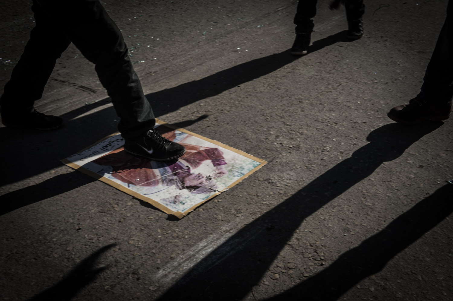  A crowd of local Libyans cheer and stomp on a Gaddafi poster in downtown Benghazi. 